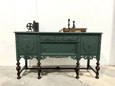 A green buffet with two drawers and three doors.
