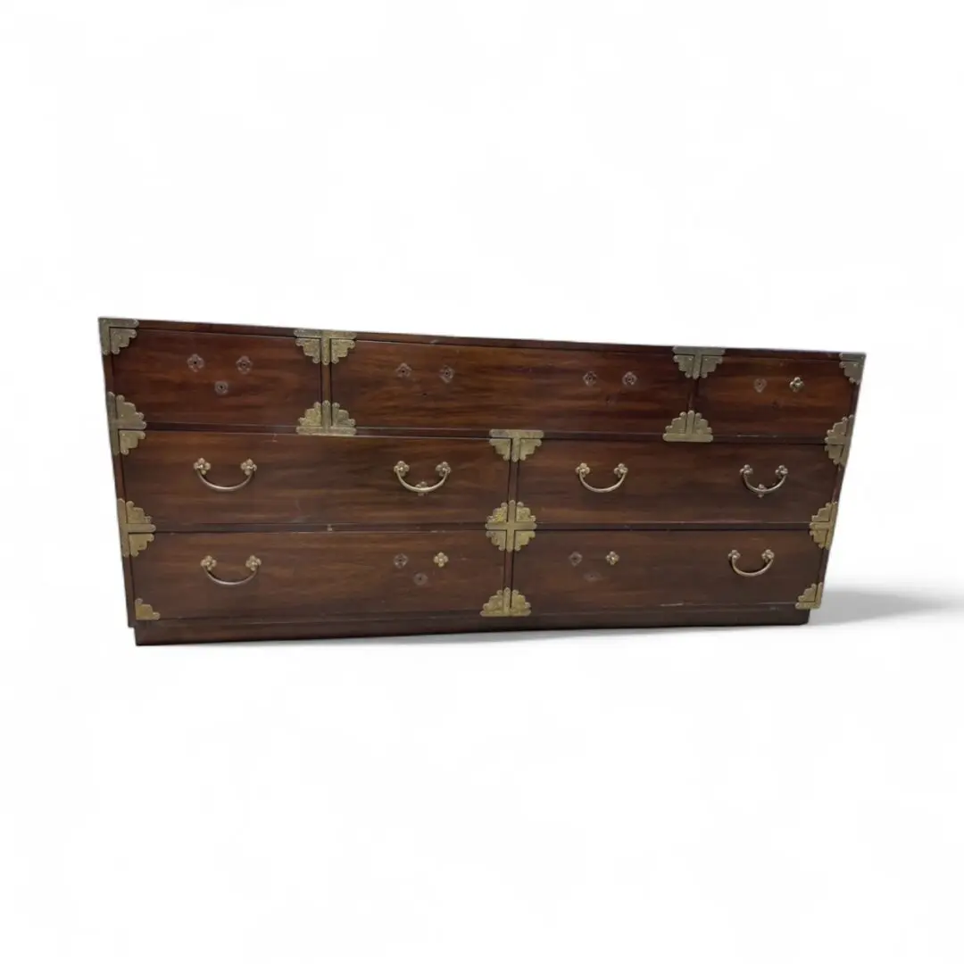 Wooden dresser with ornate metal accents.
