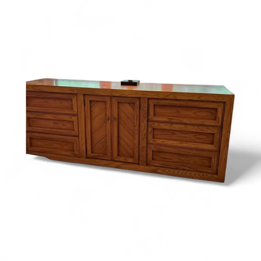 Wooden dresser with multiple drawers and doors.