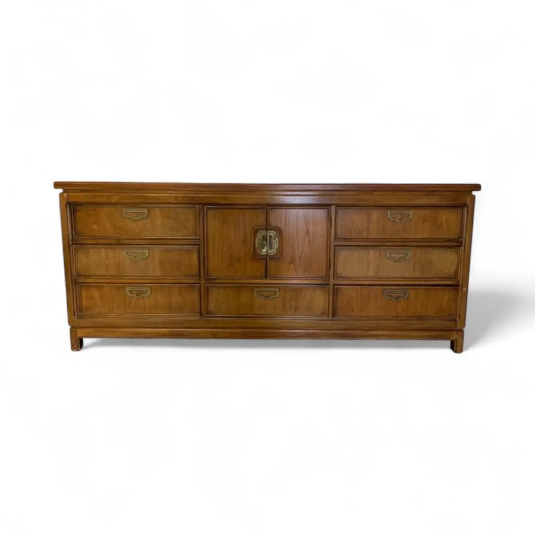 Wooden dresser with multiple drawers and handles.