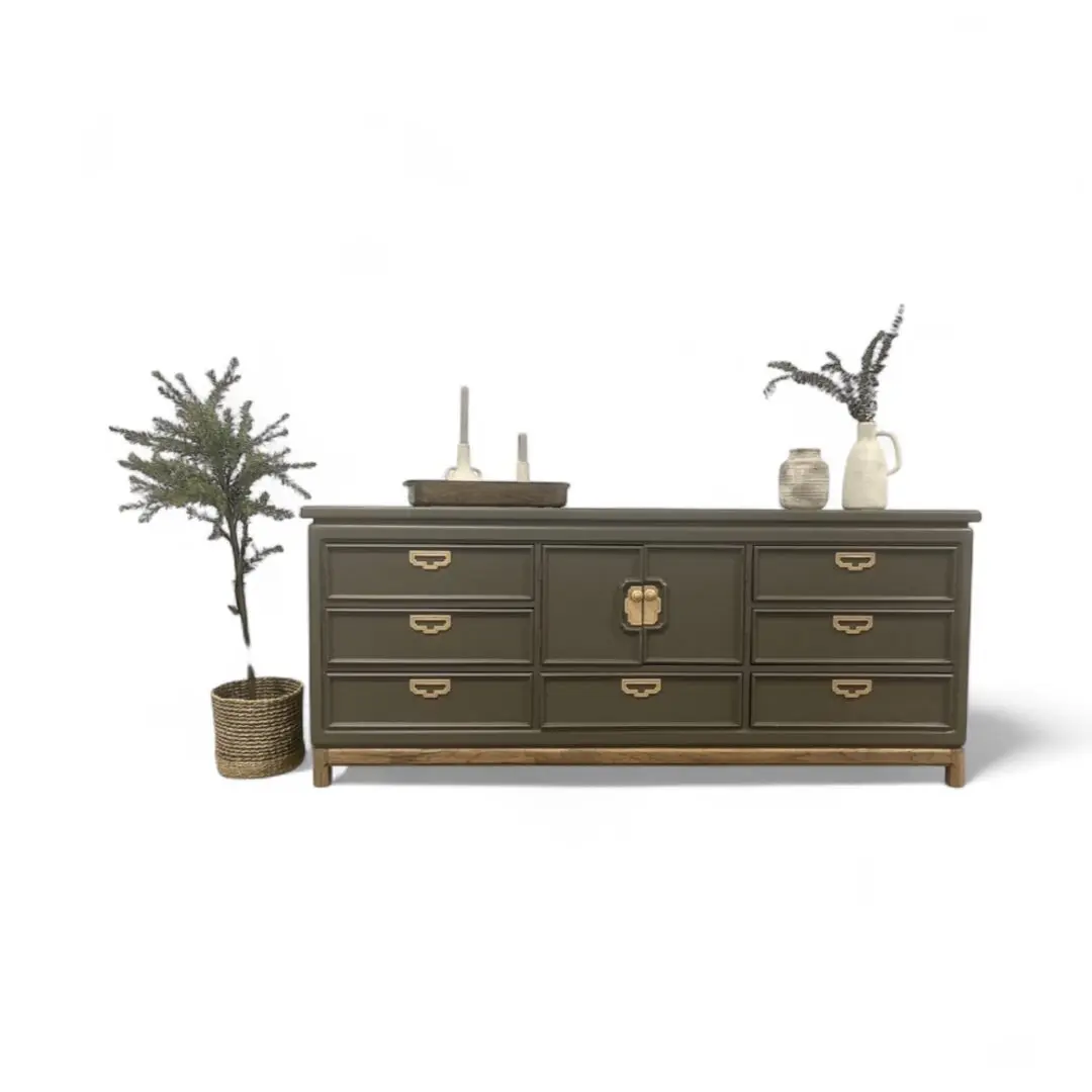 Green sideboard with plants and decor items.