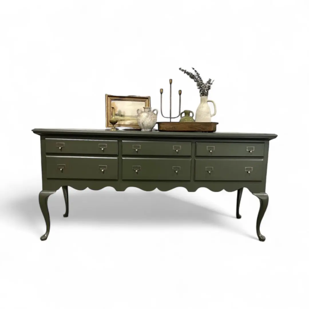 Vintage green sideboard with decorative items displayed.