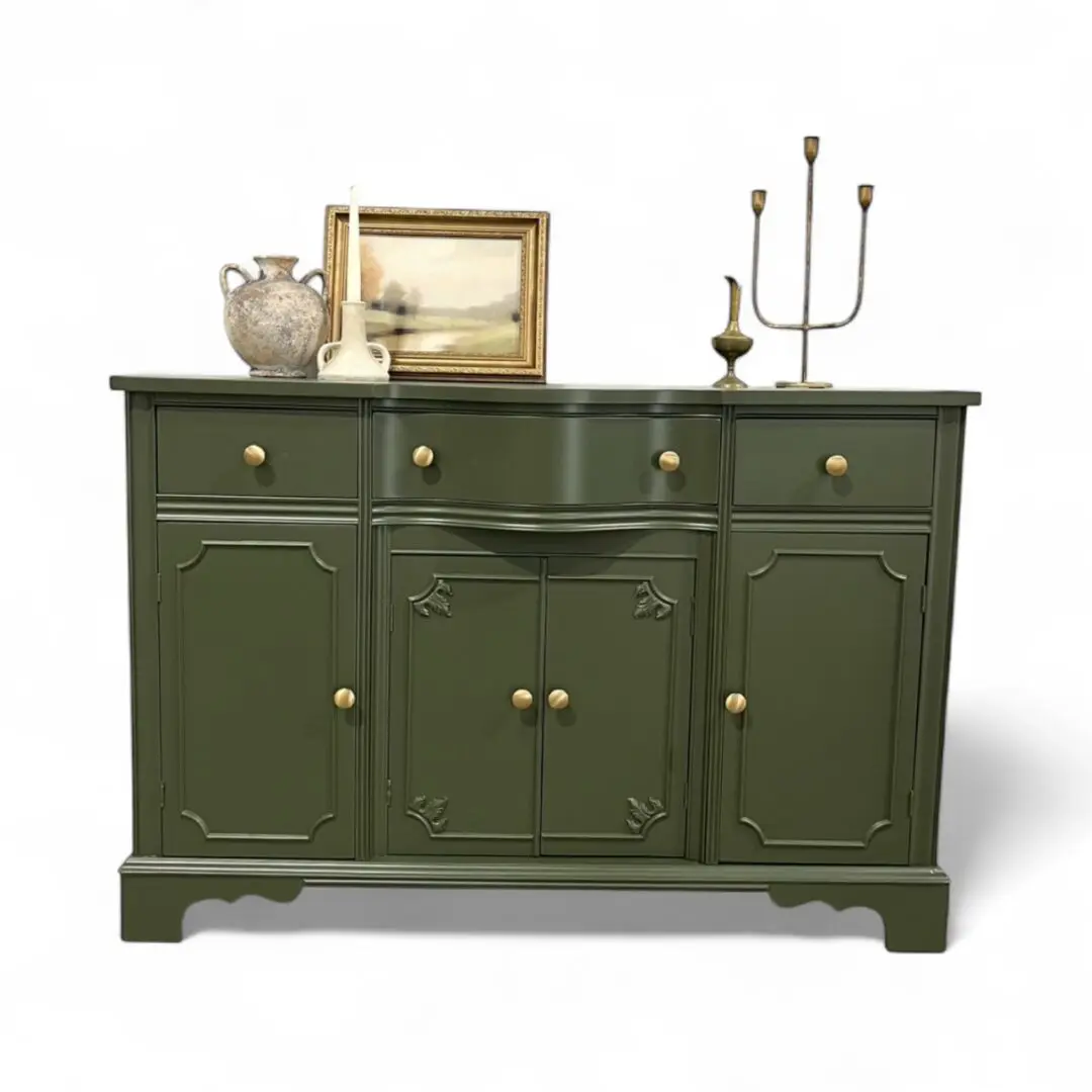 Green sideboard with decorative items on top.