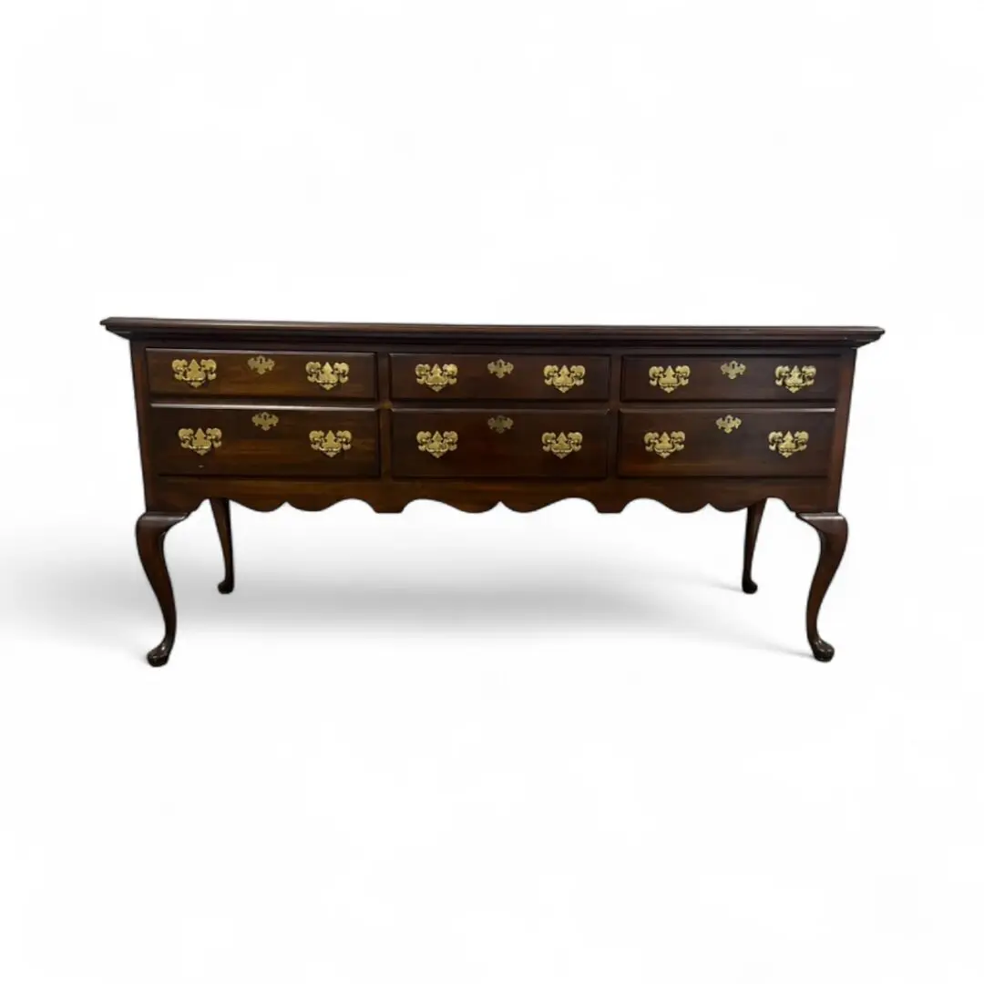Elegant wooden sideboard with ornate gold handles.