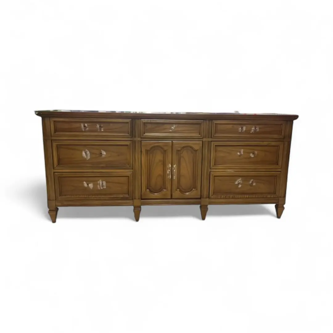 Wooden dresser with multiple drawers and cabinets.