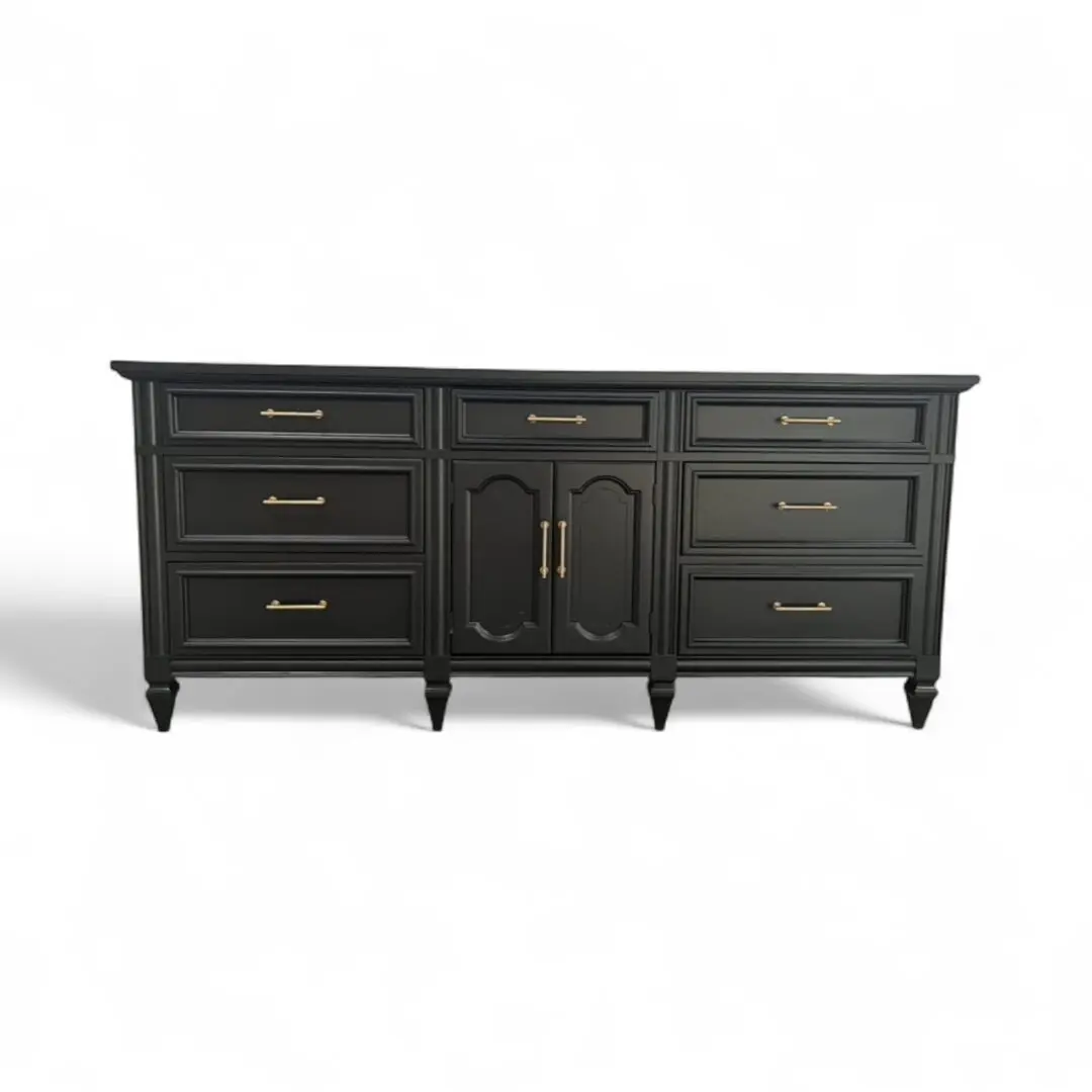 Black dresser with drawers and gold handles.