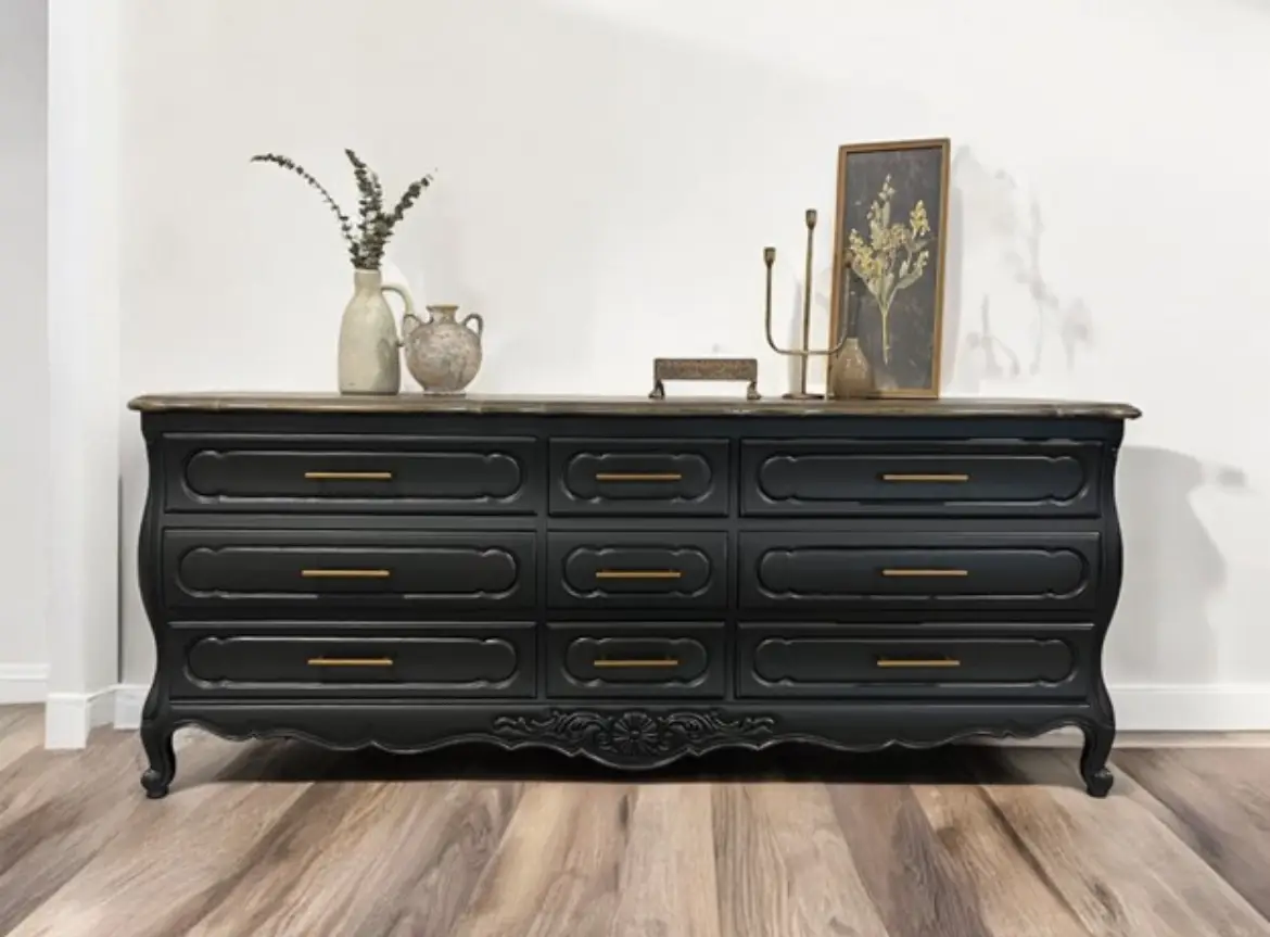 A black dresser with many drawers and a vase on top of it.